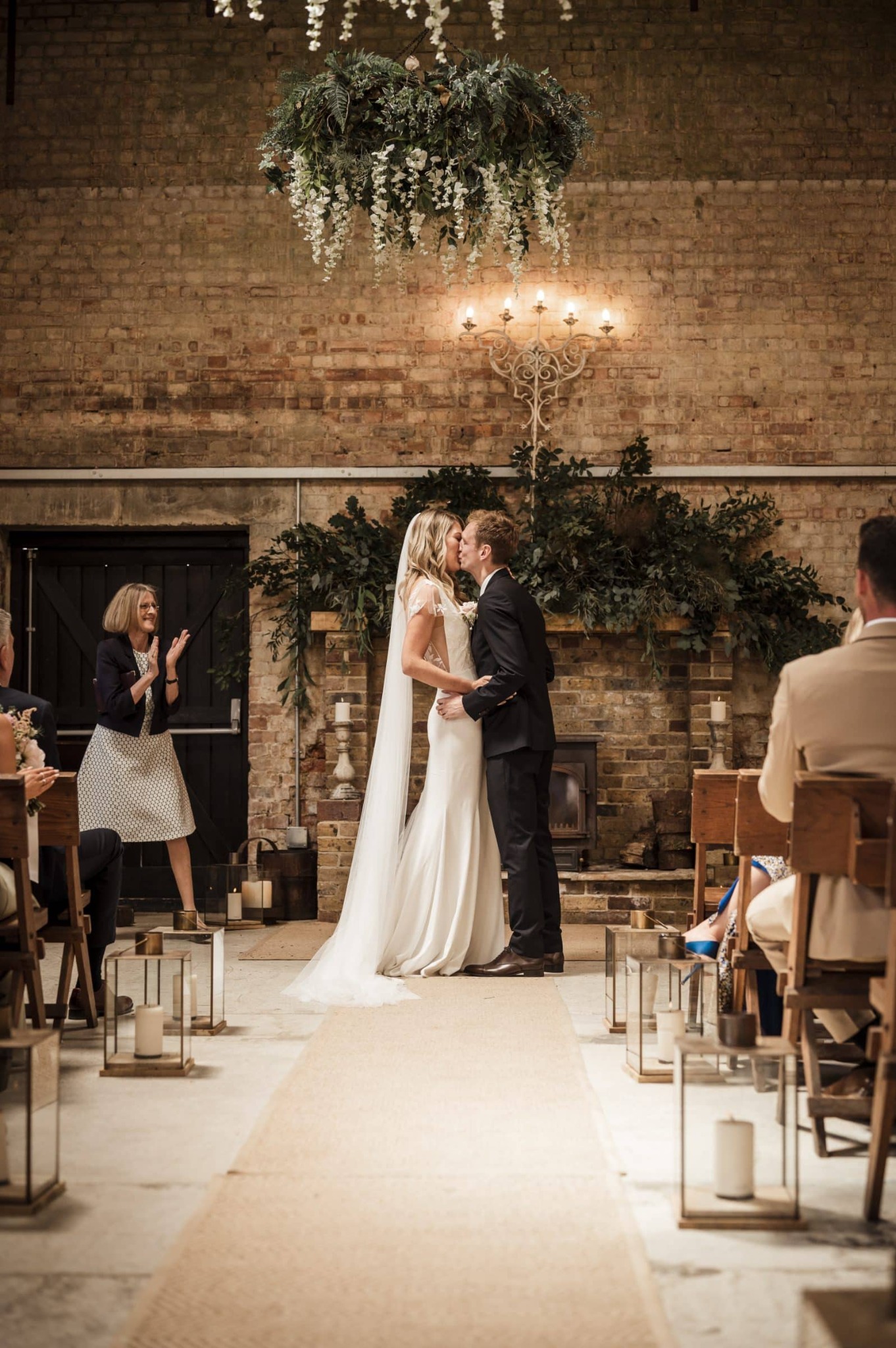 Newlyweds sharing their first kiss during a candlelit ceremony