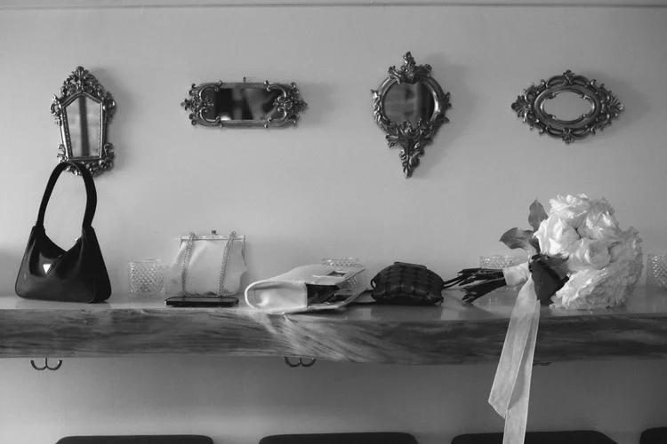 Bridal accessories and bouquet arranged beneath vintage mirrors