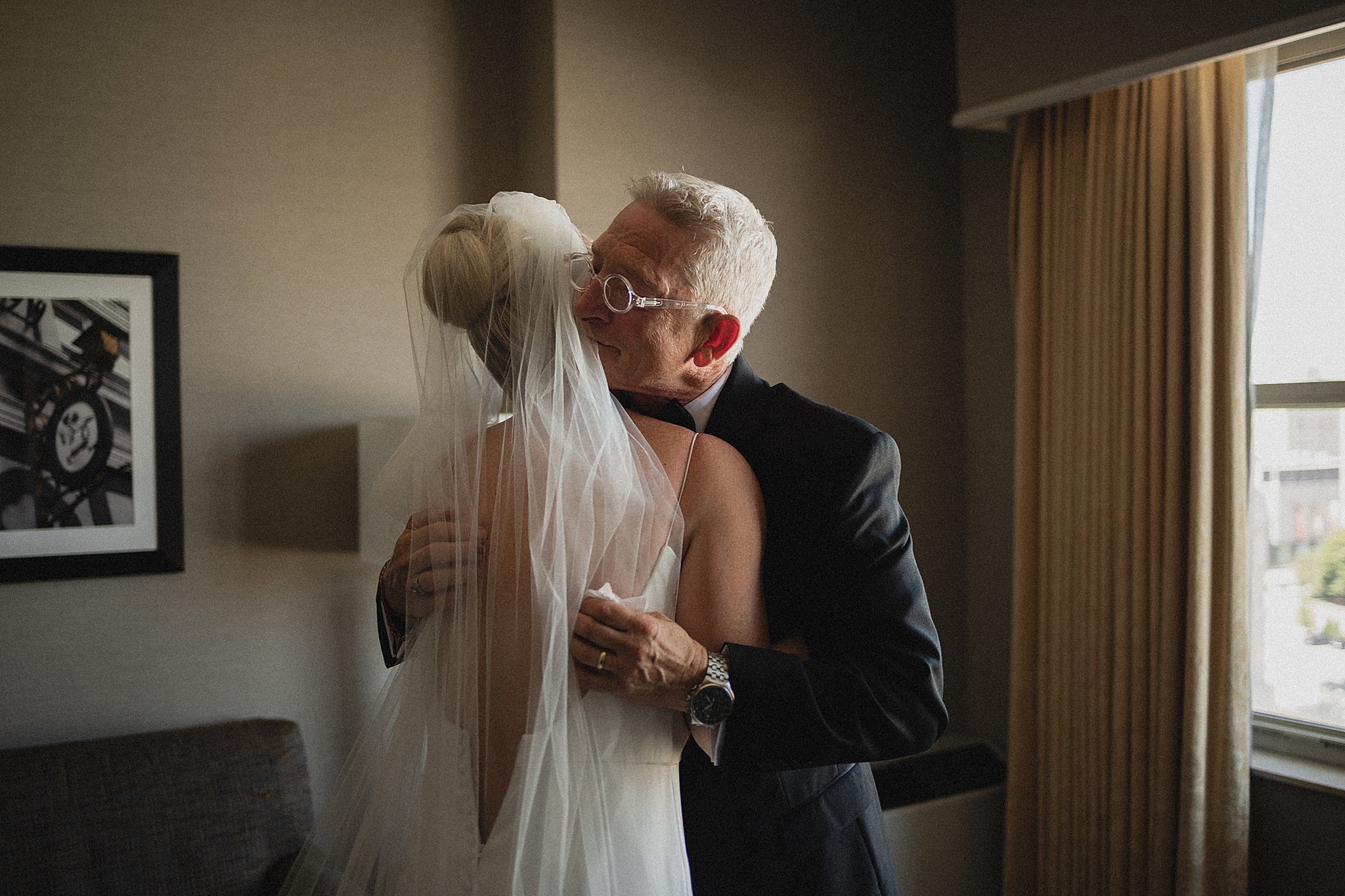 Father embracing the bride during an emotional wedding morning moment