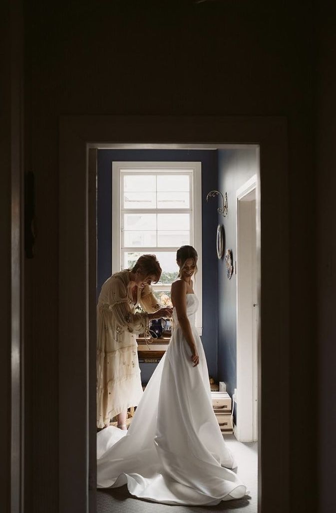 Bride getting ready in soft window light before the wedding ceremony