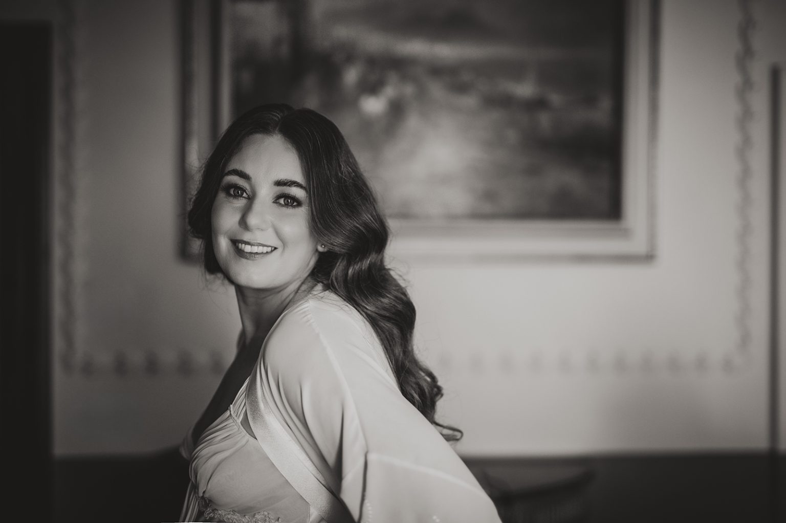 Black and white portrait of a smiling bride getting ready for her wedding