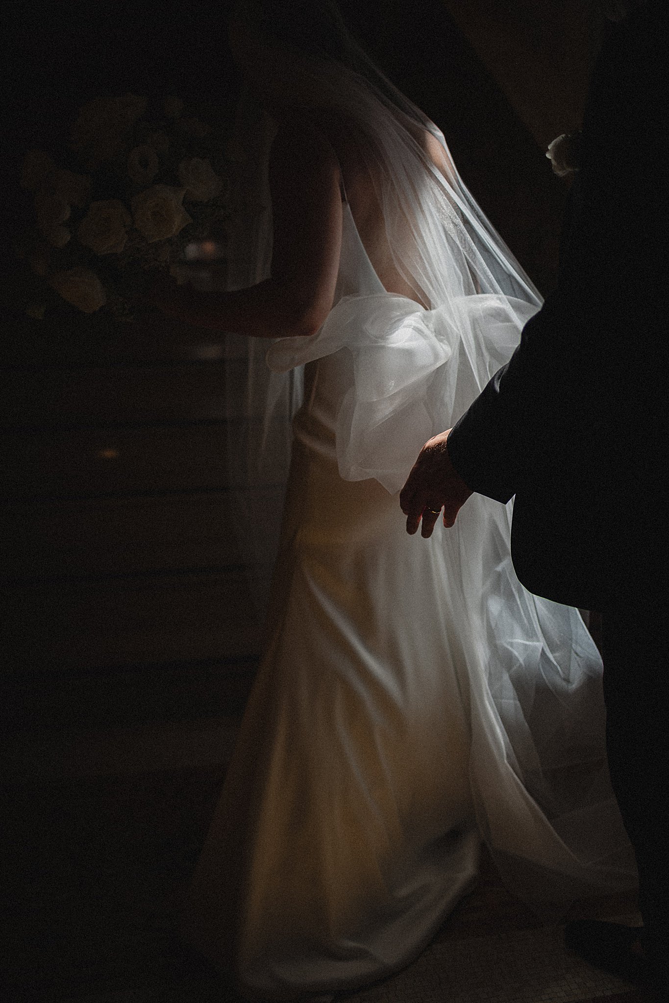 Bride and veil photographed in dramatic low light