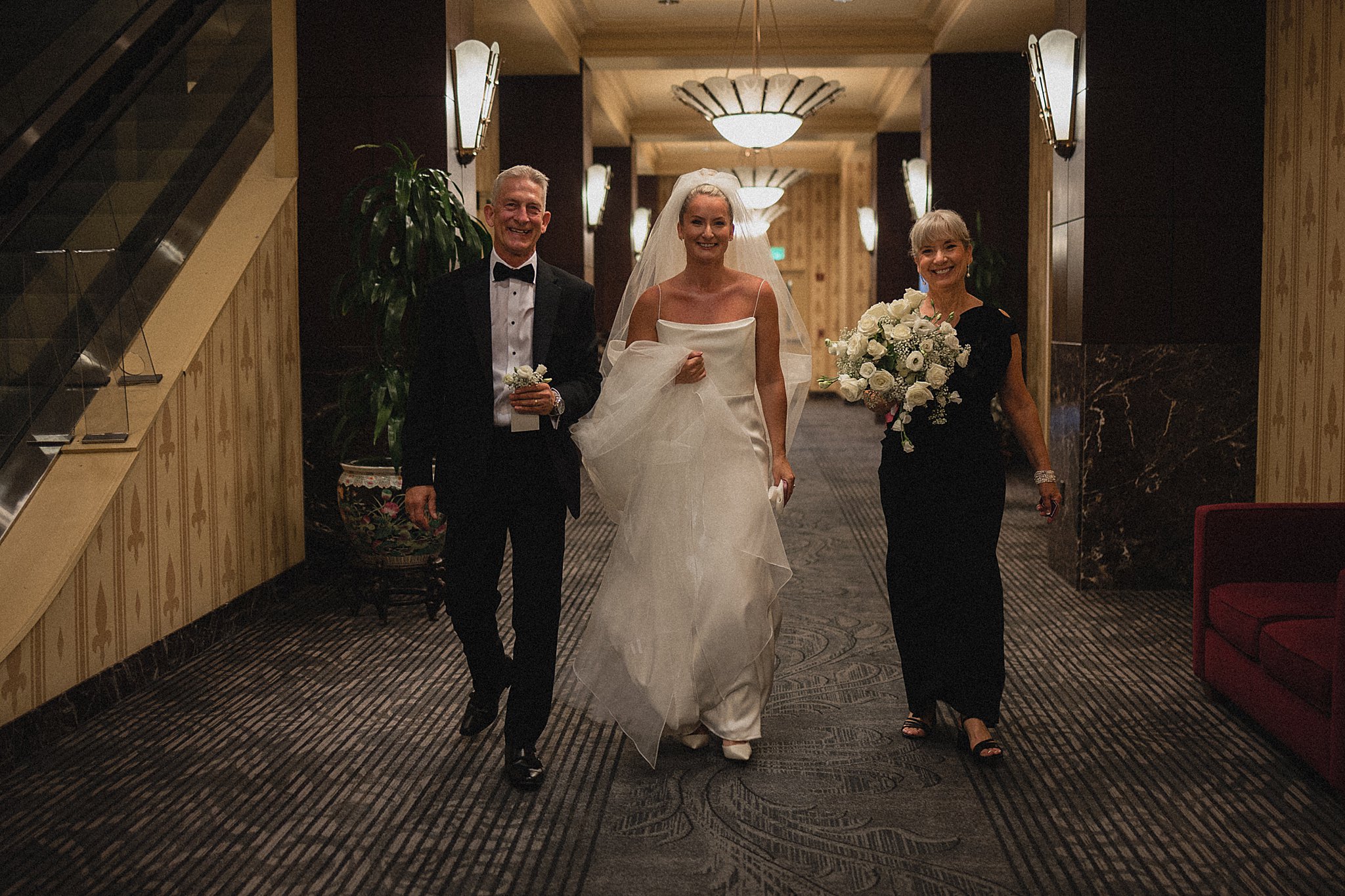 Bride walking with her parents before the wedding ceremony