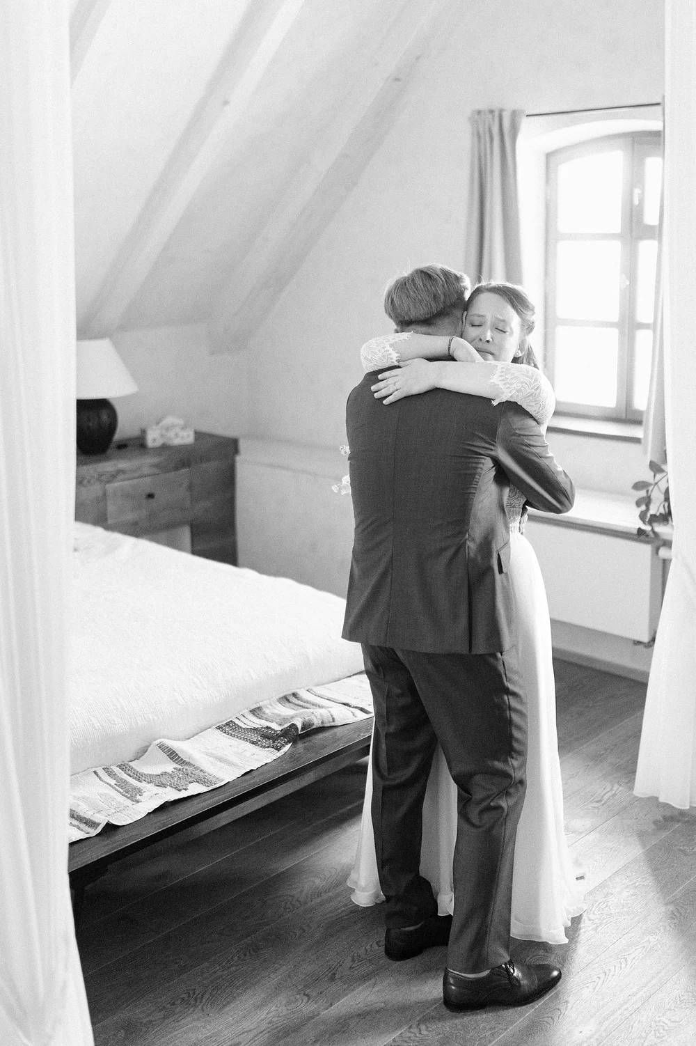 Emotional black and white moment as newlyweds embrace indoors