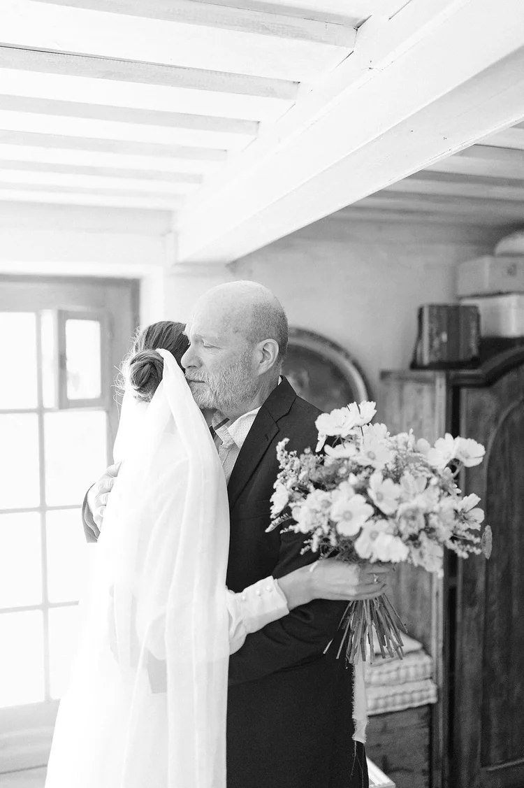 Father embracing the bride before the wedding ceremony in black and white