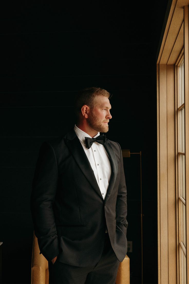 Groom portrait beside warm window light before the wedding