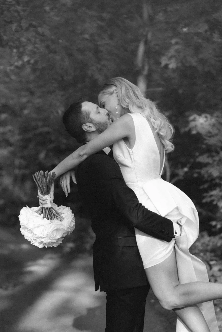 Newlyweds embracing and laughing outdoors in black and white